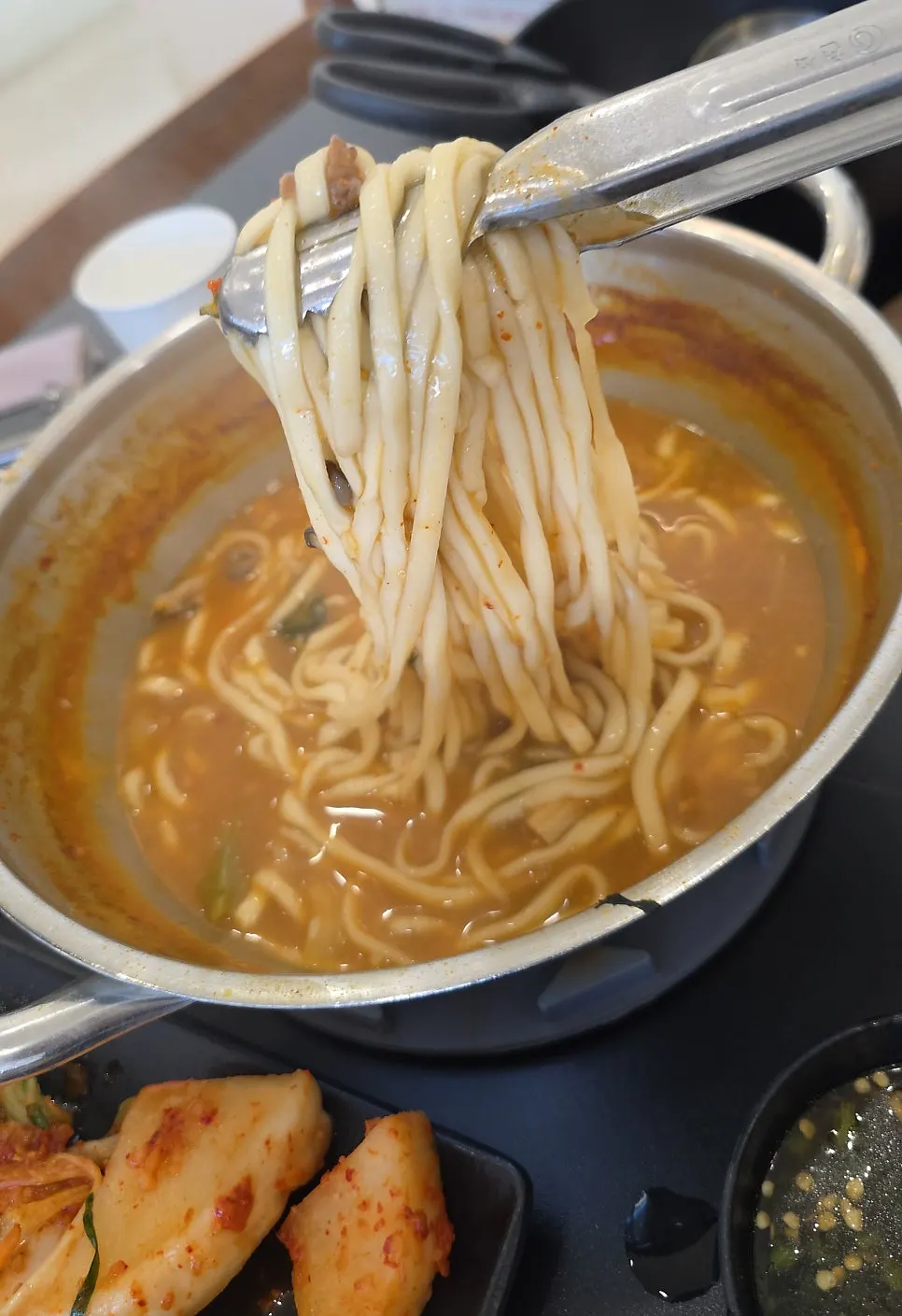 Table set with shabu-kalguksu and crispy seafood pajeon together