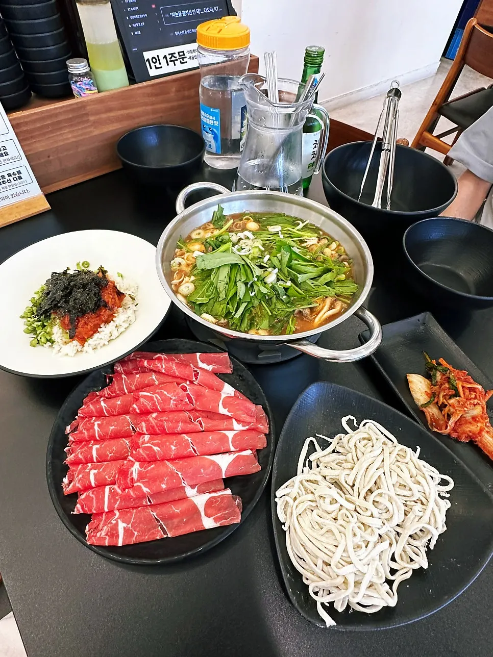 Shabu-shabu spread with meat, vegetables, and mushrooms laid out