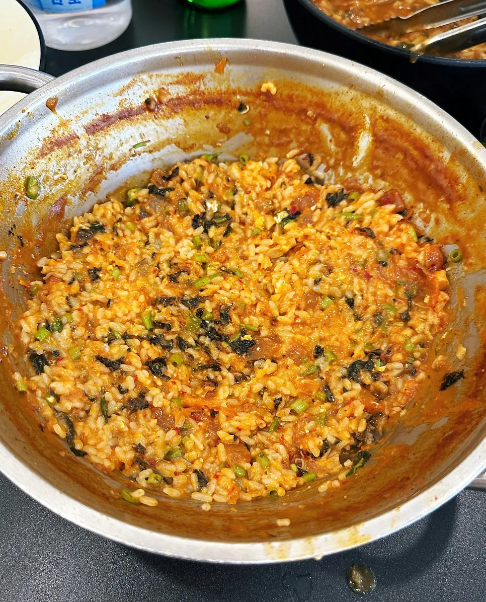 Finishing fried rice made with stir-fried kimchi, seaweed, and sesame oil