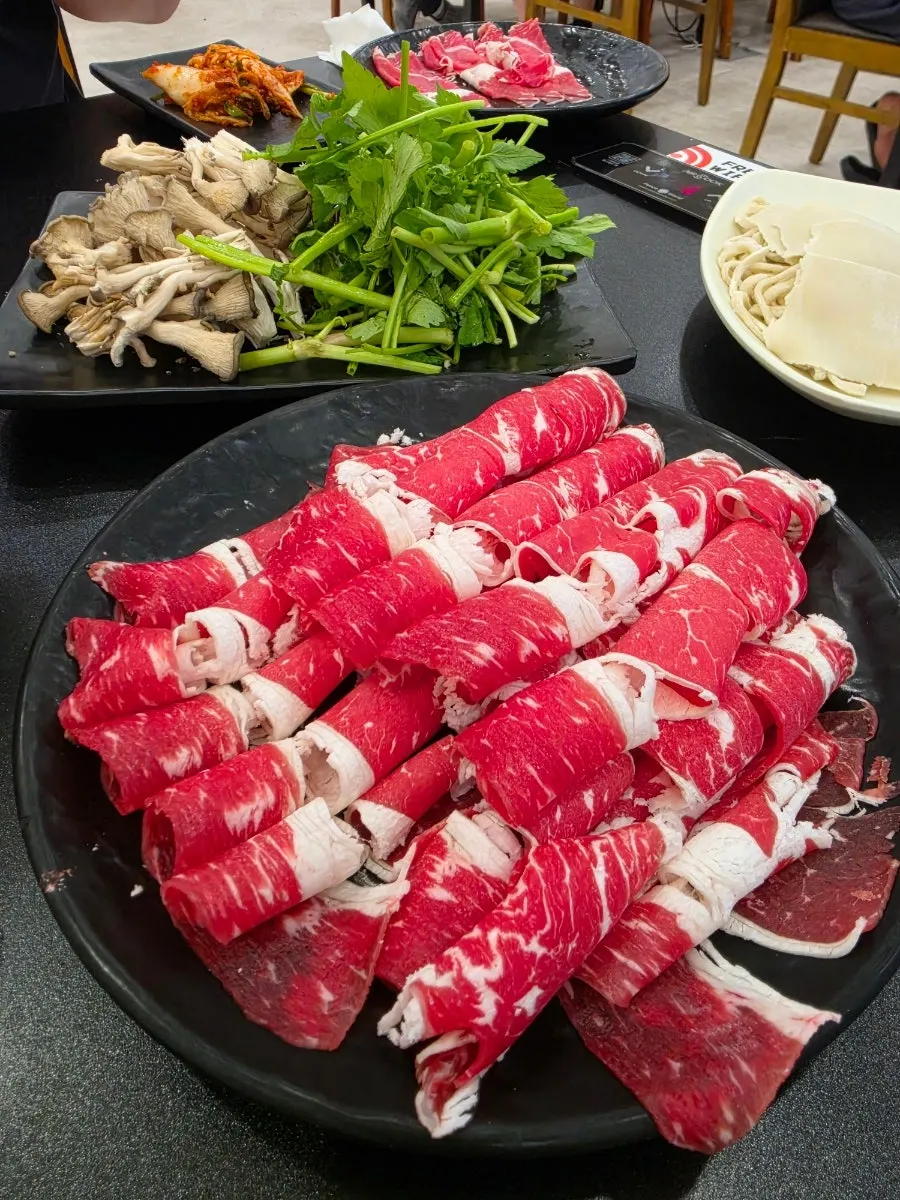 A bite of meat and vegetables wrapped in flat kalguksu noodle