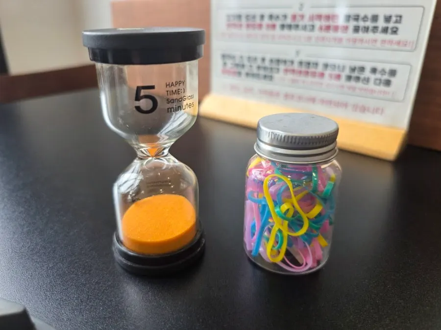 Hourglass and hair tie placed on the table