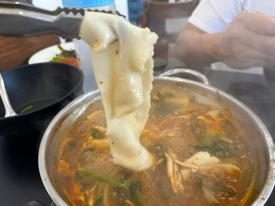 Hand-pounded flat noodles added into the broth