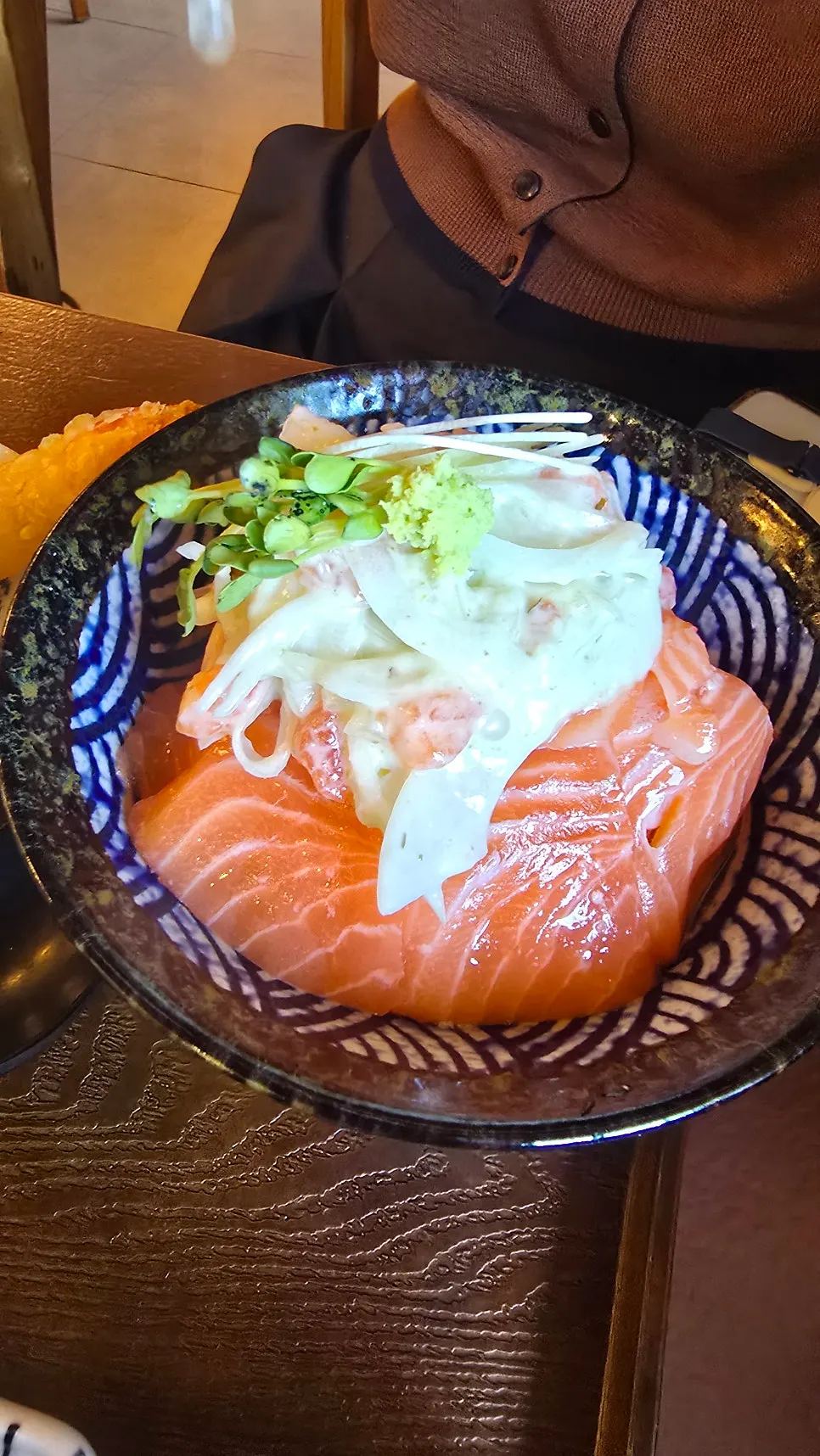 Salmon rice bowl topped with onion and radish sprouts