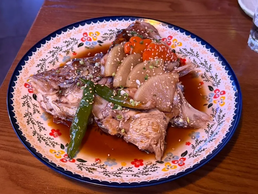 Braised sea bream head topped with radish, carrot, and chili