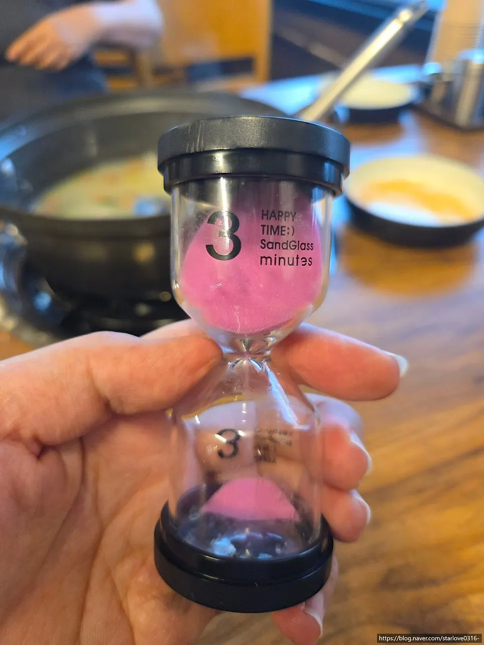 Pot of simmering kalguksu with the hourglass timer