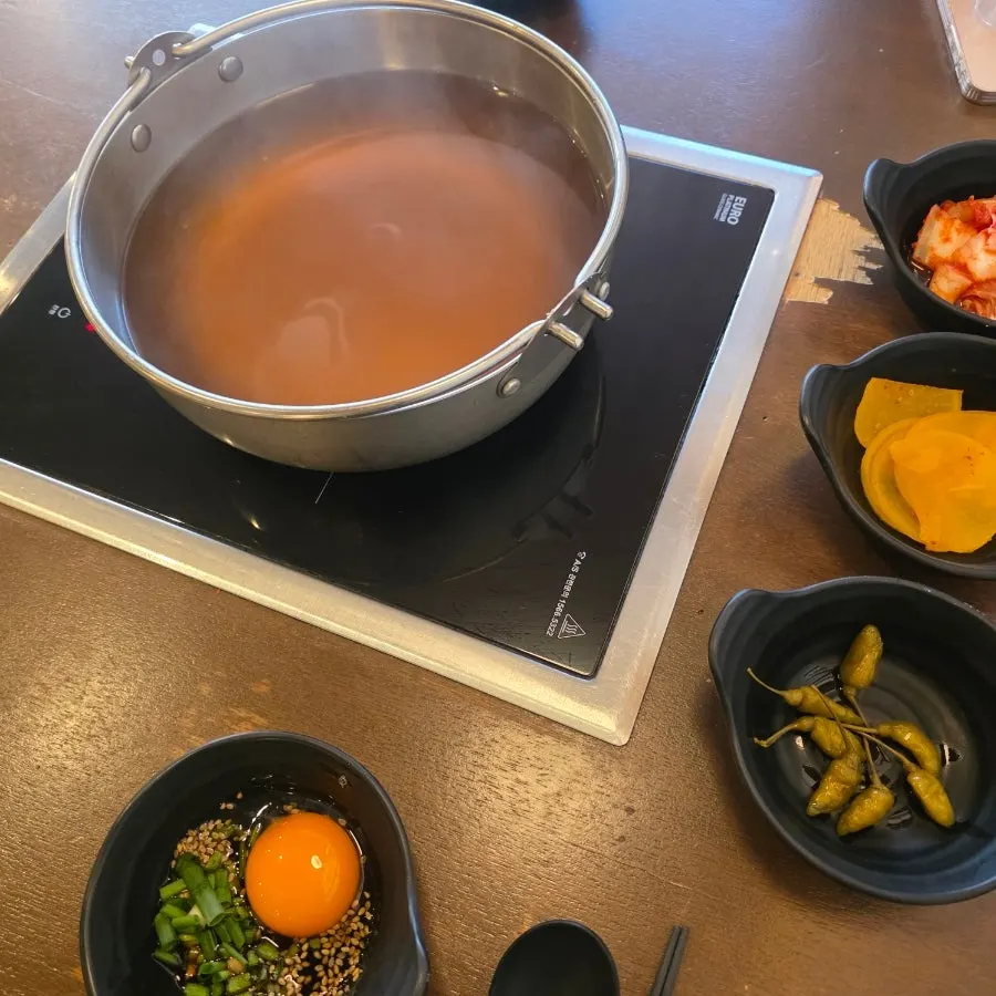 Pot of shabu-shabu broth with vegetables and mushrooms