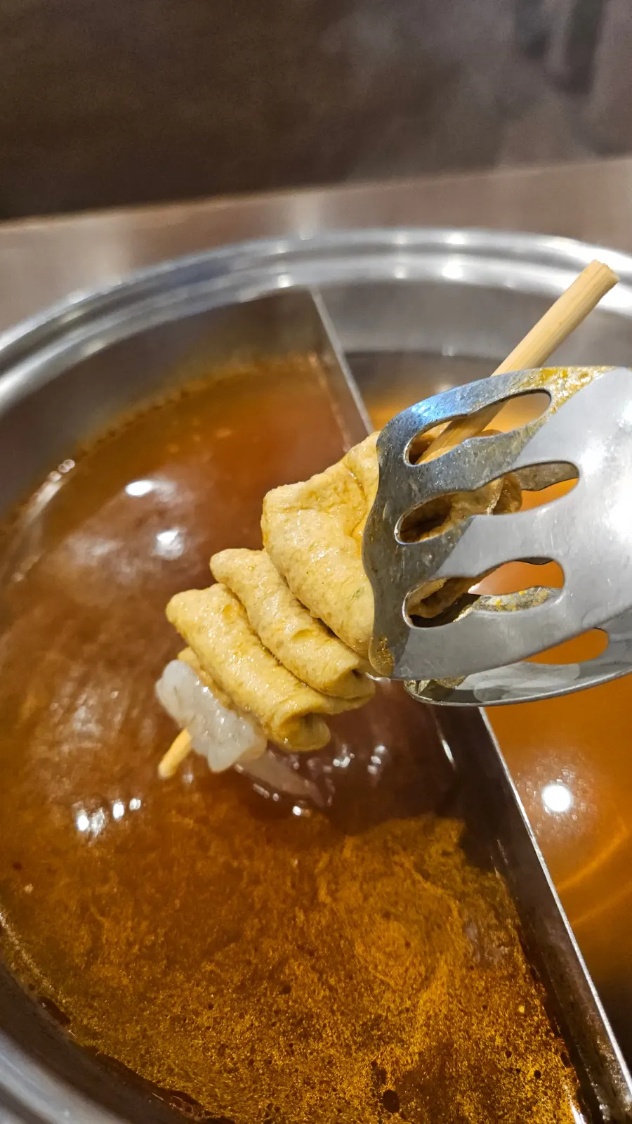 Putting fish cake into the mala broth