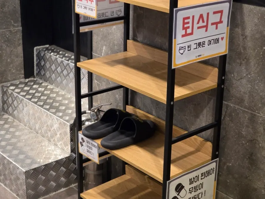 Corner of the café with the dish return counter and slippers