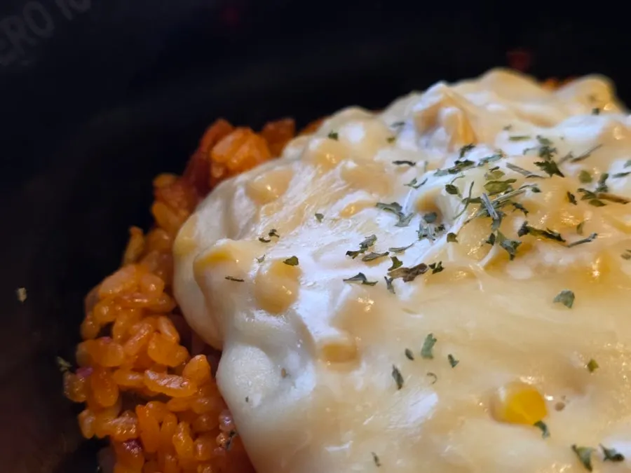 Close-up of kimchi fried rice covered in corn mayo